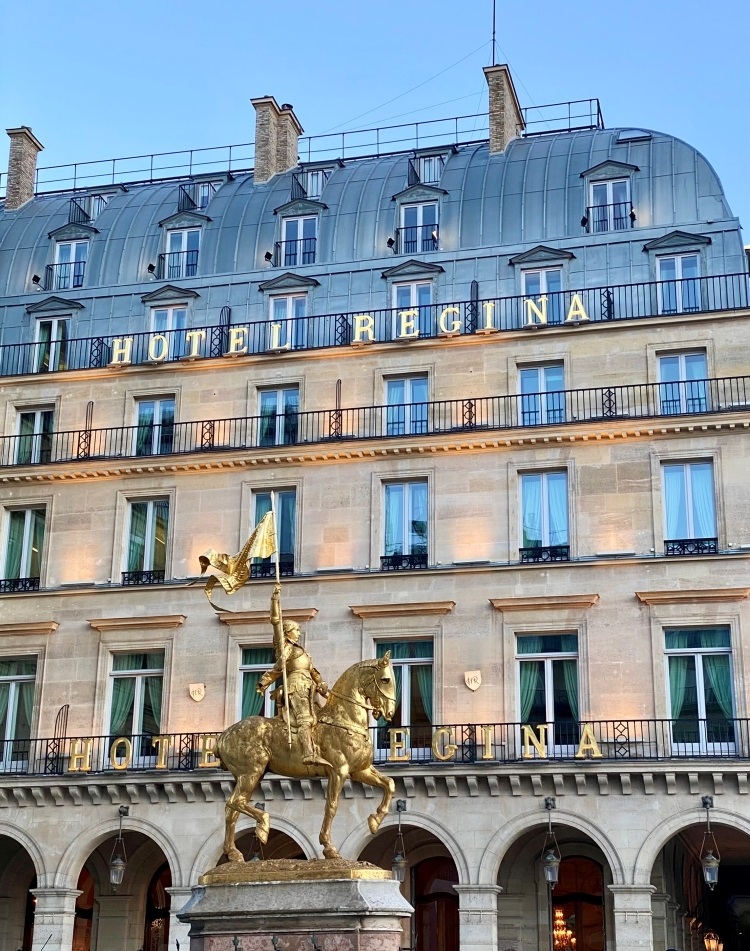 grand olf hotel in Haussmann style of architecture with a gold statue in front of it