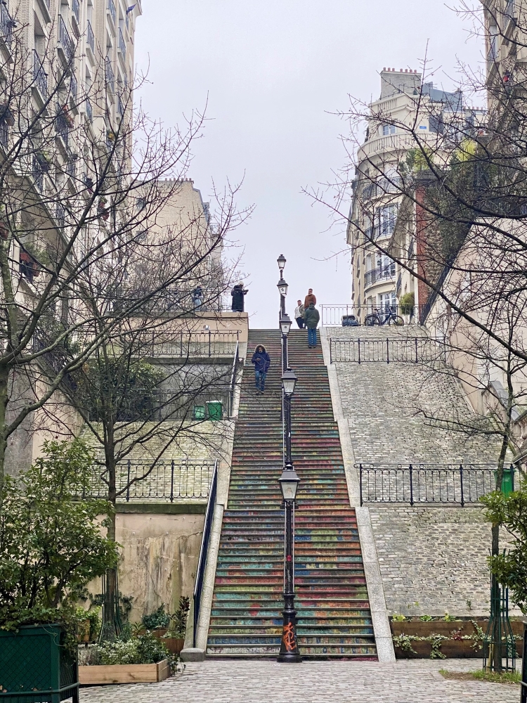 Long set of painted steps with between tall apartment buildings in Montmartre